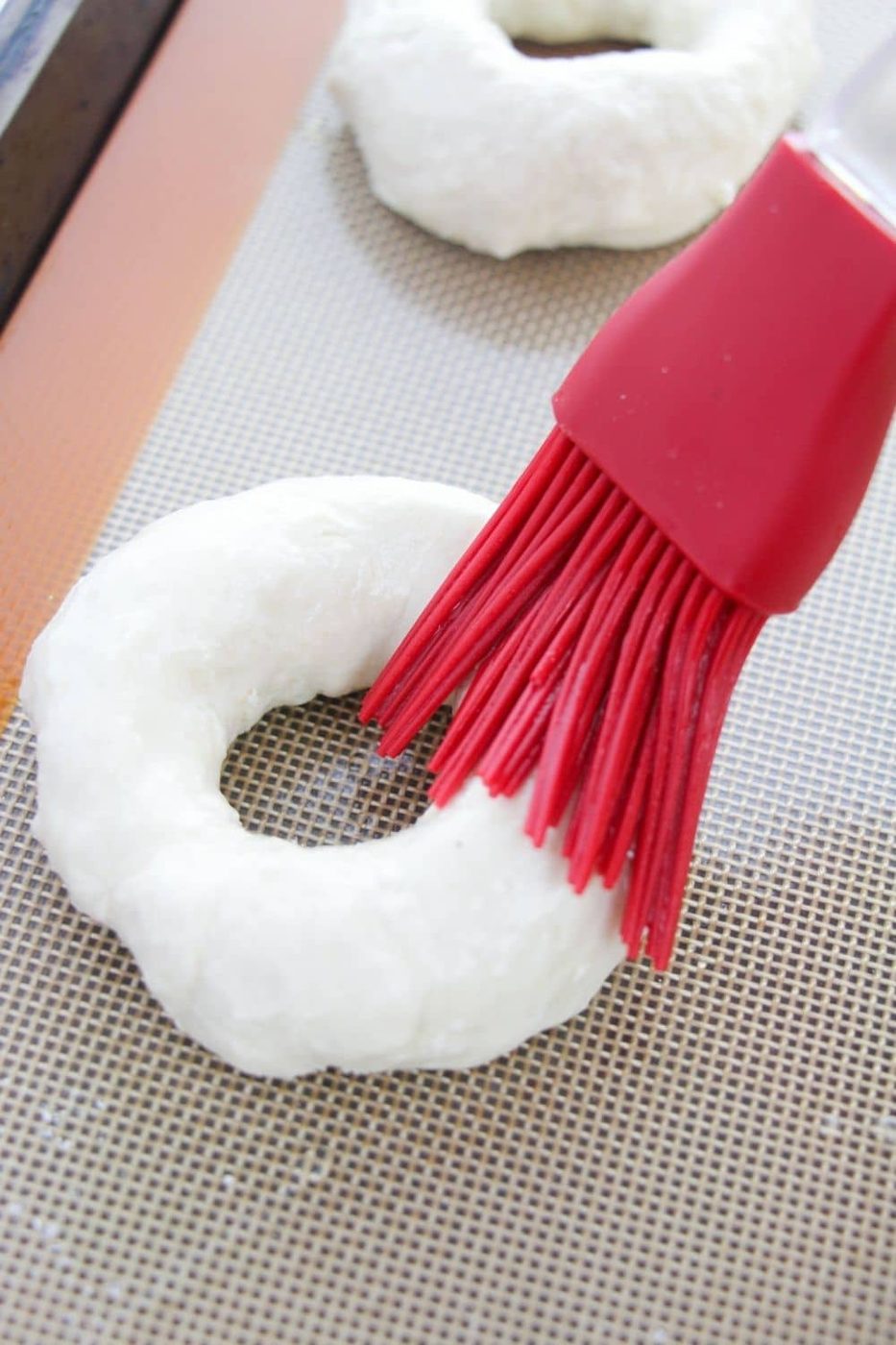 using a silicone brush for wiping egg whites on bagels
