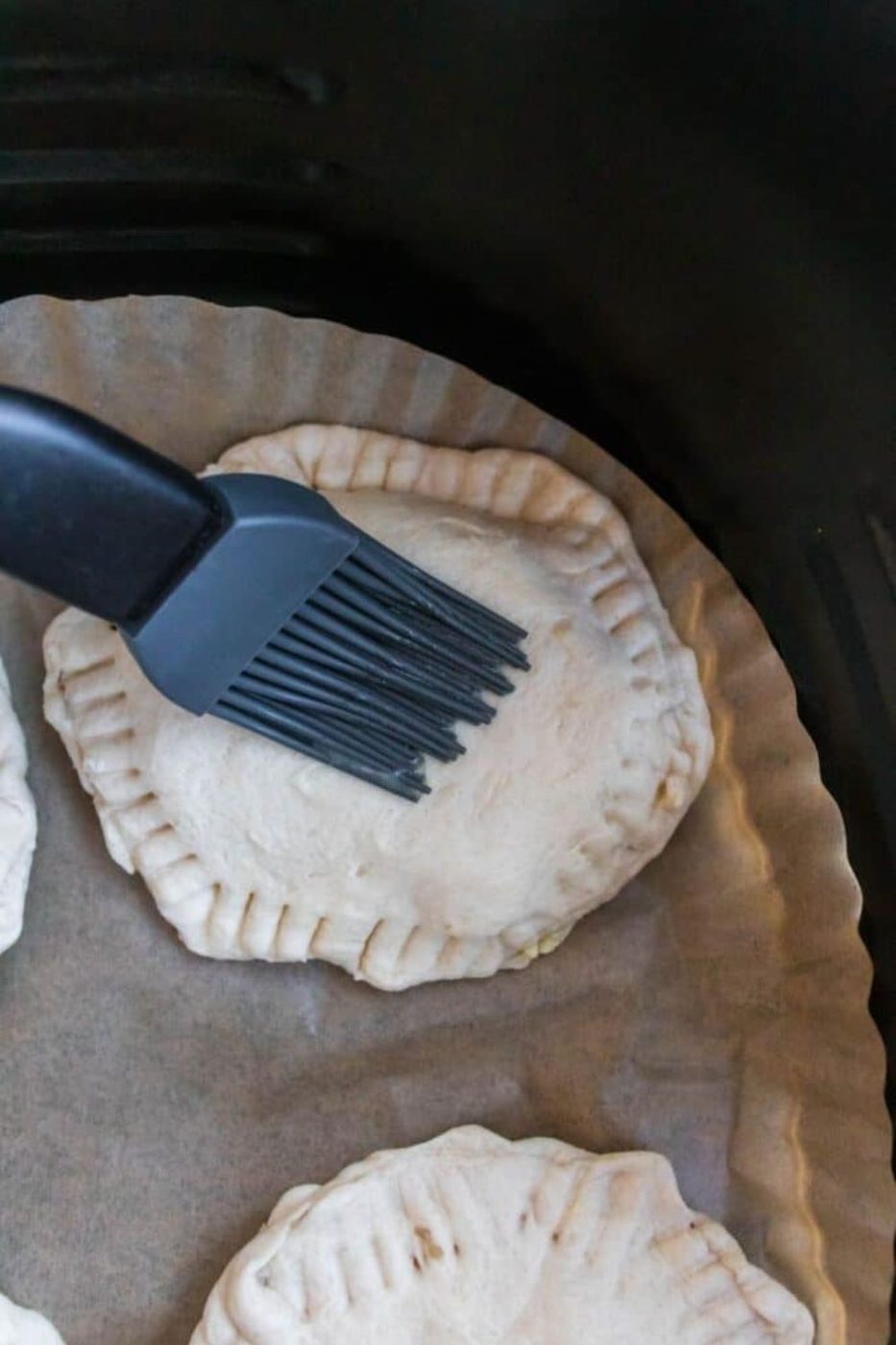 breakfast bomb sandwich in air fryer being brushed