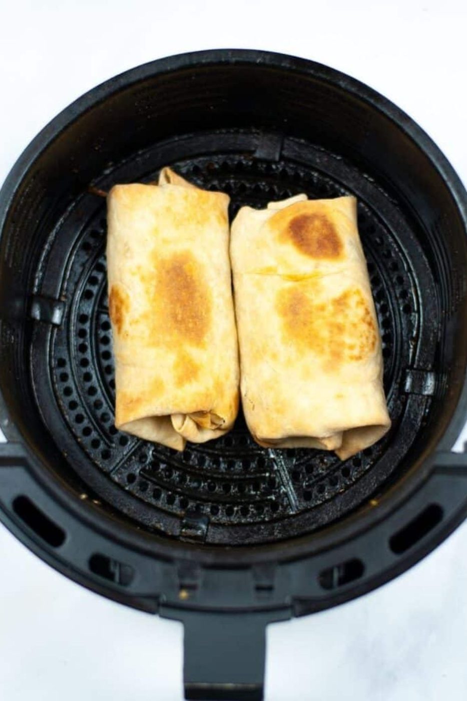 Air Fryer Breakfast Chimichangas in an air fryer basket on the table 