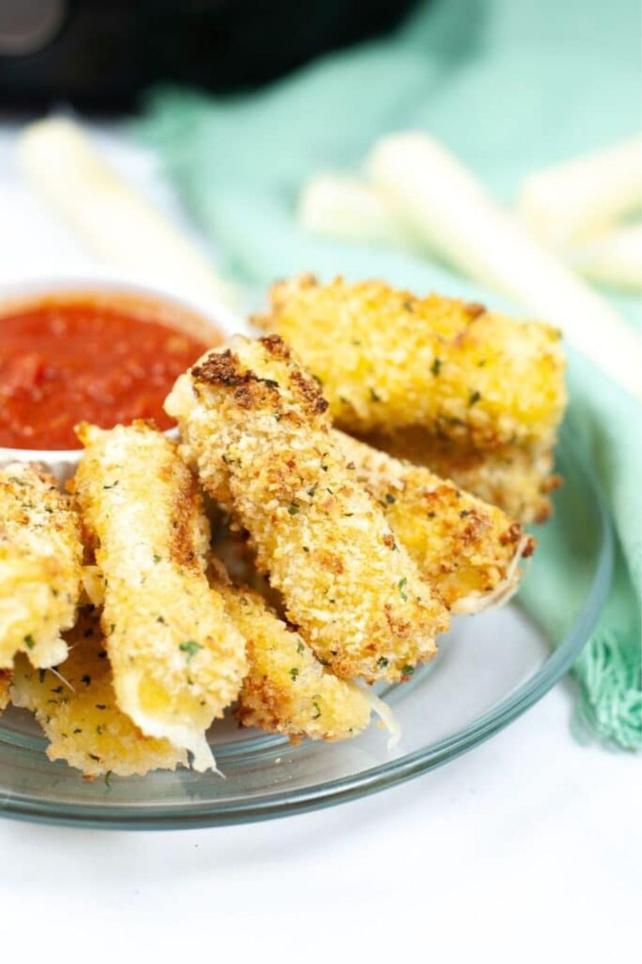 plate of mozzarella sticks with marinara sauce in a bowl