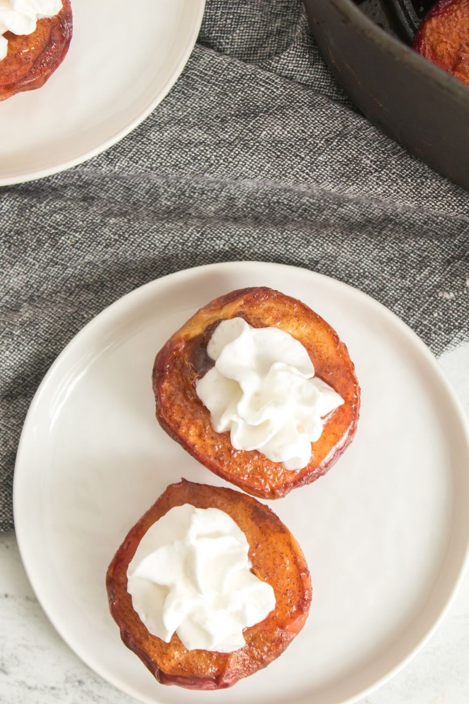 Air Fryer Peaches on a plate with whipped cream on top 