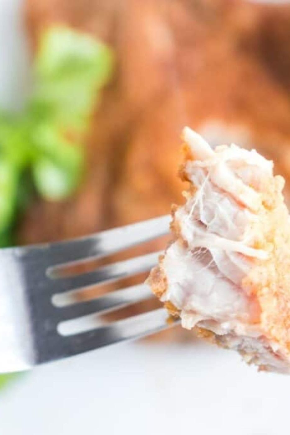 fork with a bite of pork chop on it