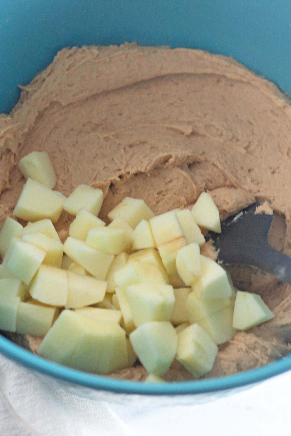 diced apples with apple muffin batter mixed in bottom of bowl