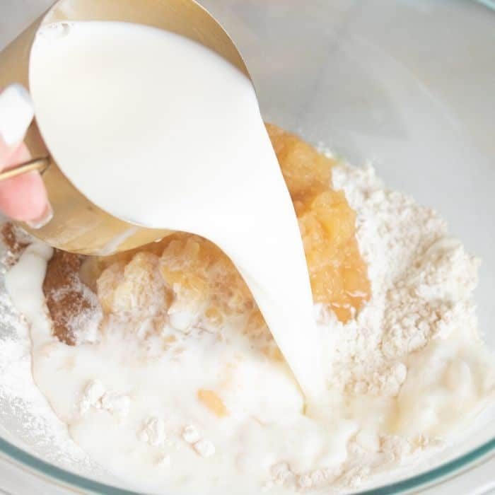adding milk into a bowl for pancakes