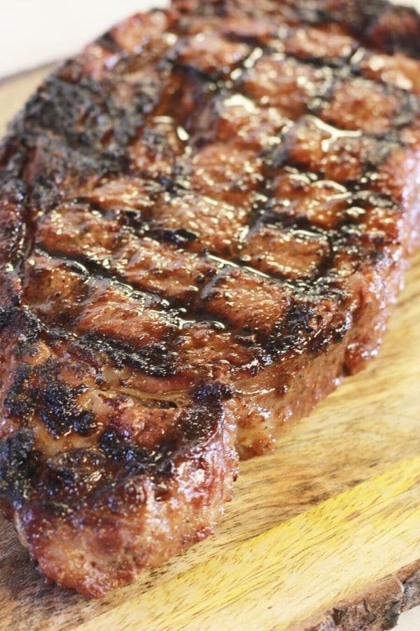 juicy steak on a wooden cutting board resting