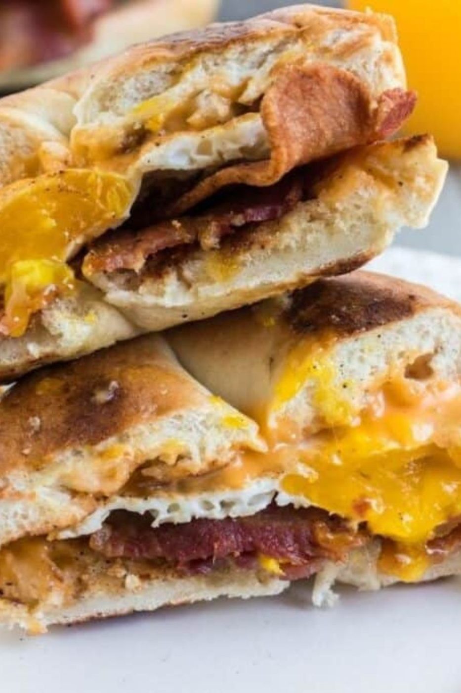 Blackstone Bacon Egg and Cheese on a Bun cut in half on a plate 