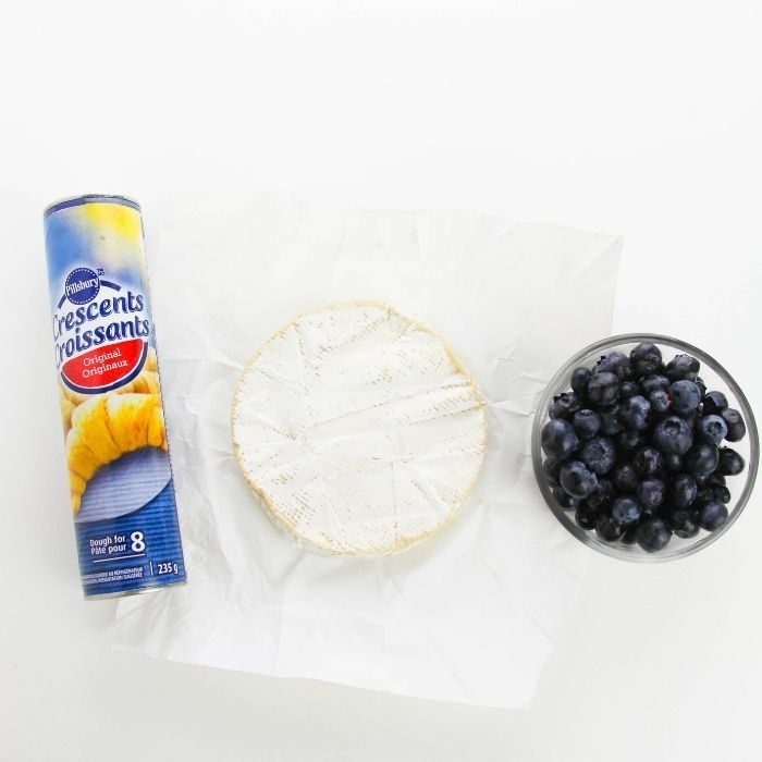 crescent rolls, brie and blueberries on white counter
