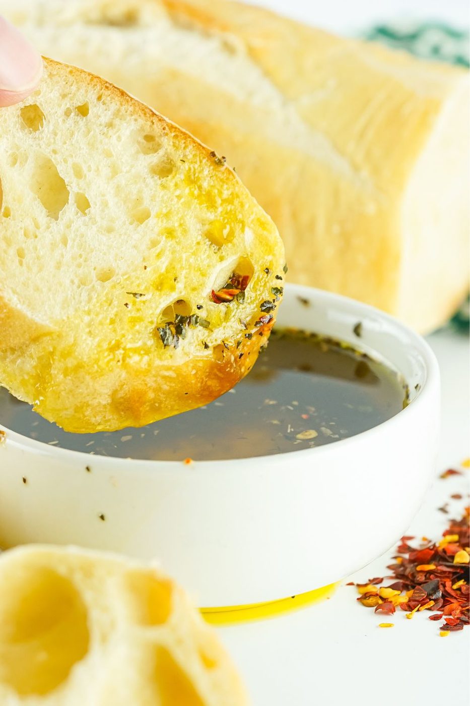 oil in a bowl with bread that has been dipped in it on top 