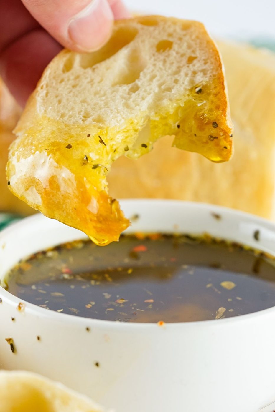 piece of bread dipped in bread dip with a bite taken out 