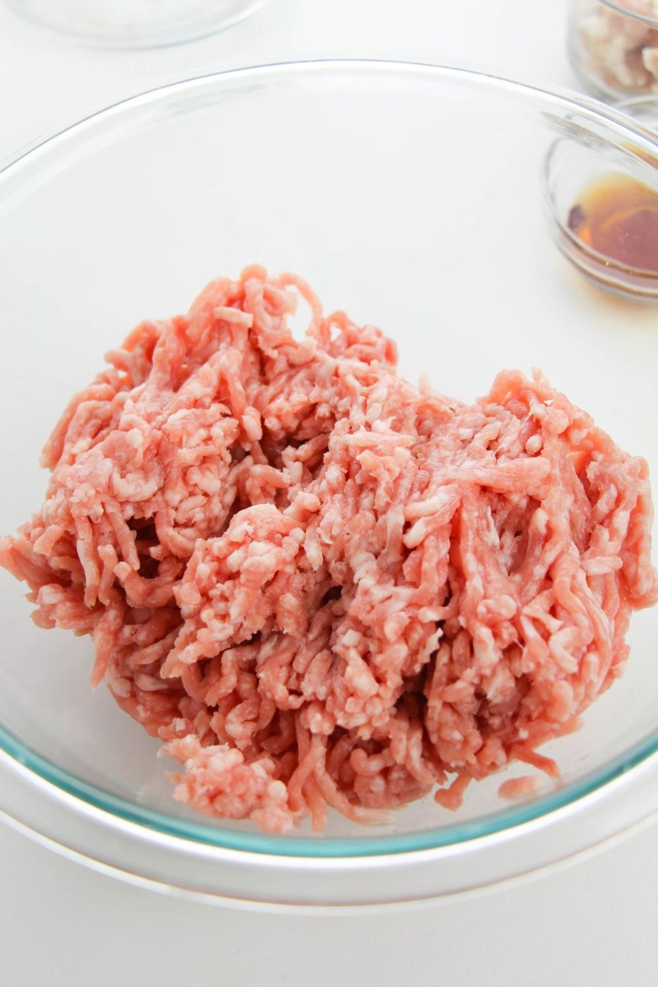ground pork in a glass bowl on white counter