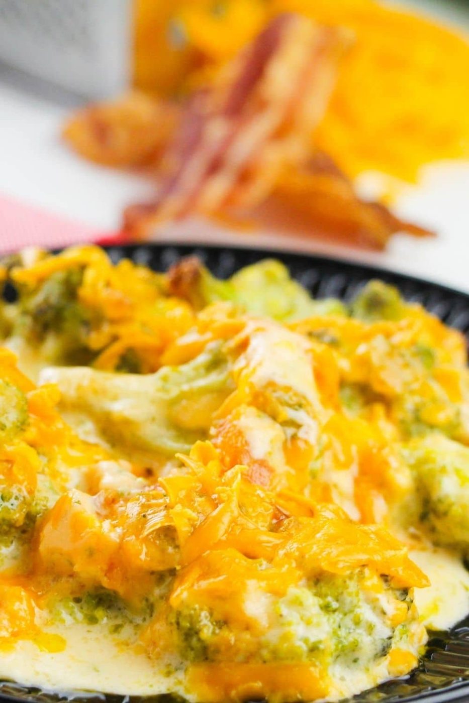 plate with broccoli casserole with bacon and cheese behind it 
