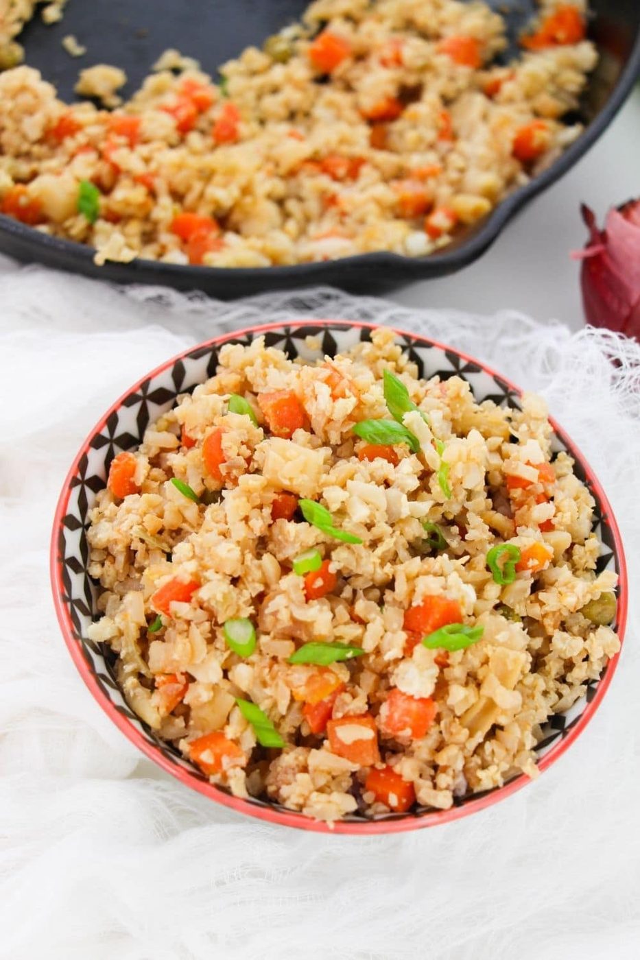 bowl of cauli rice with skillet behind it