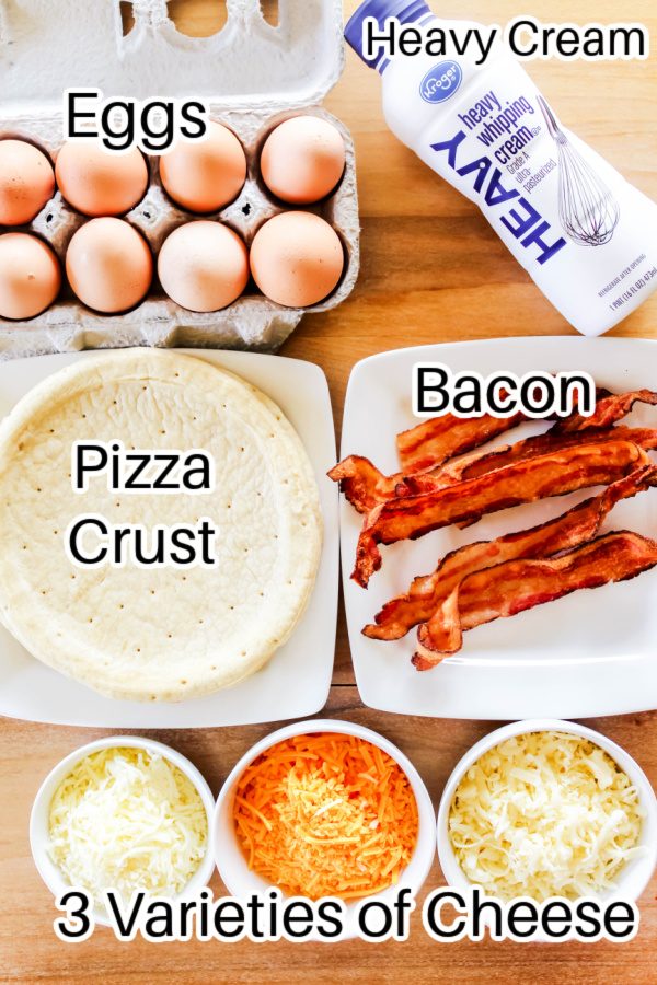 ingredients for breakfast pizza laid out with labels on wooden counter