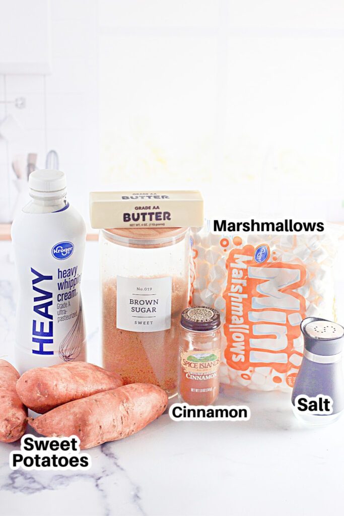 ingredients for sweet potato fries on marble counter. Heavy cream, butter, brown sugar, cinnamon, sweet potatoes, etc. 