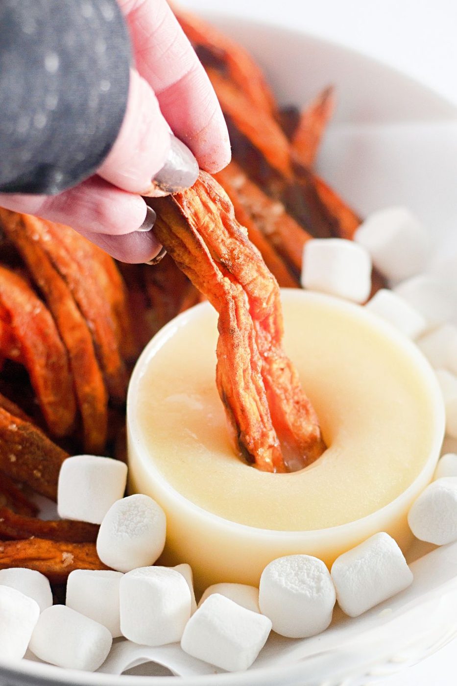 dipping sweet potatoes in marshmallow sauce