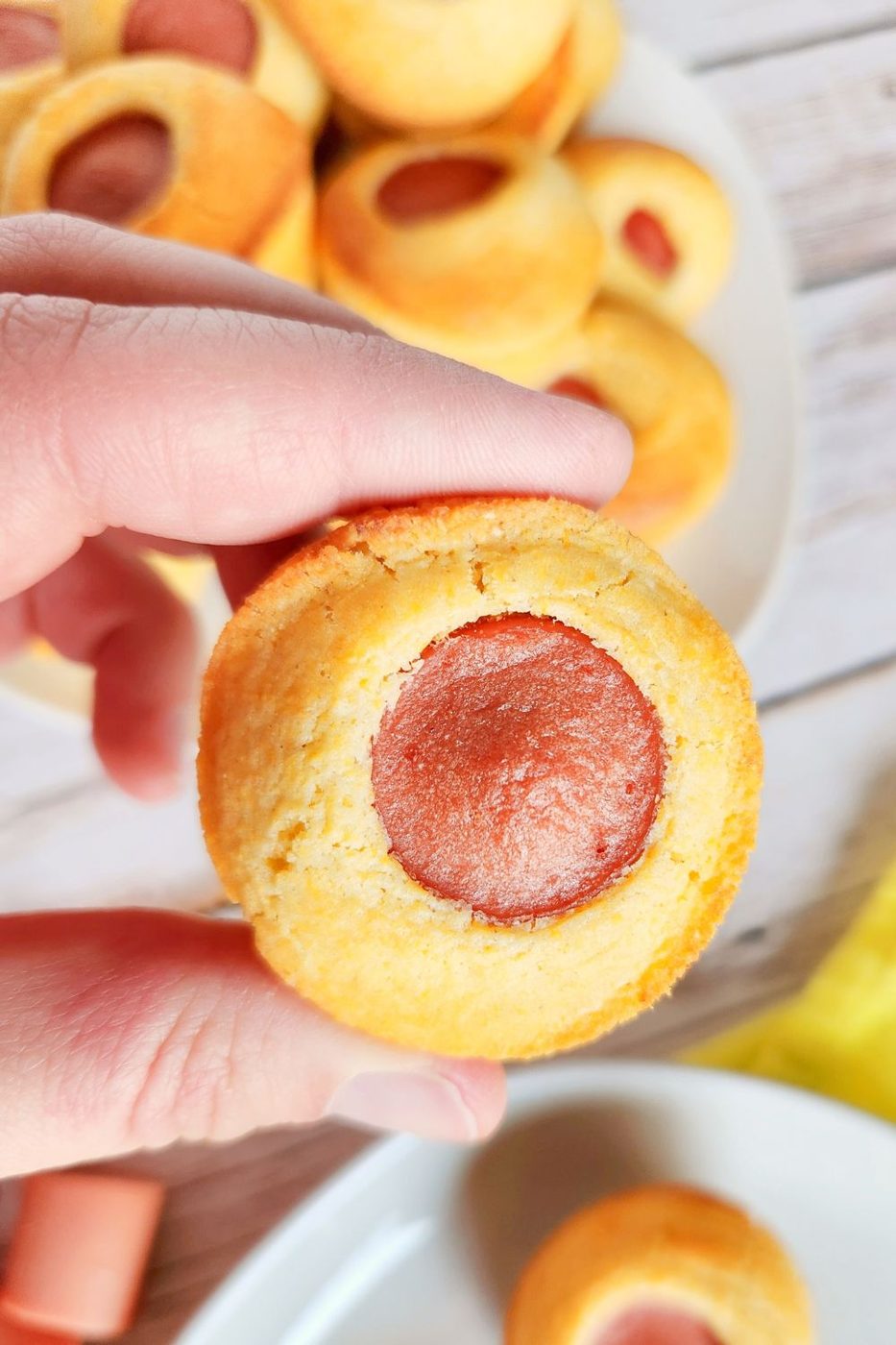 hot dog corn muffins being held in hand