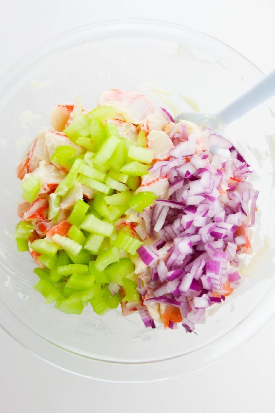 celery and onions on top of crab meat in a bowl