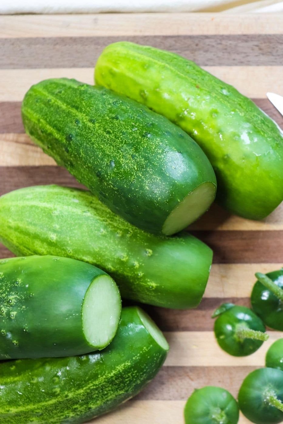 cucumbers on a cutting board with tips cut off 