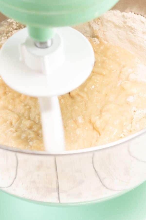 bread dough in a stand mixer getting stirred 