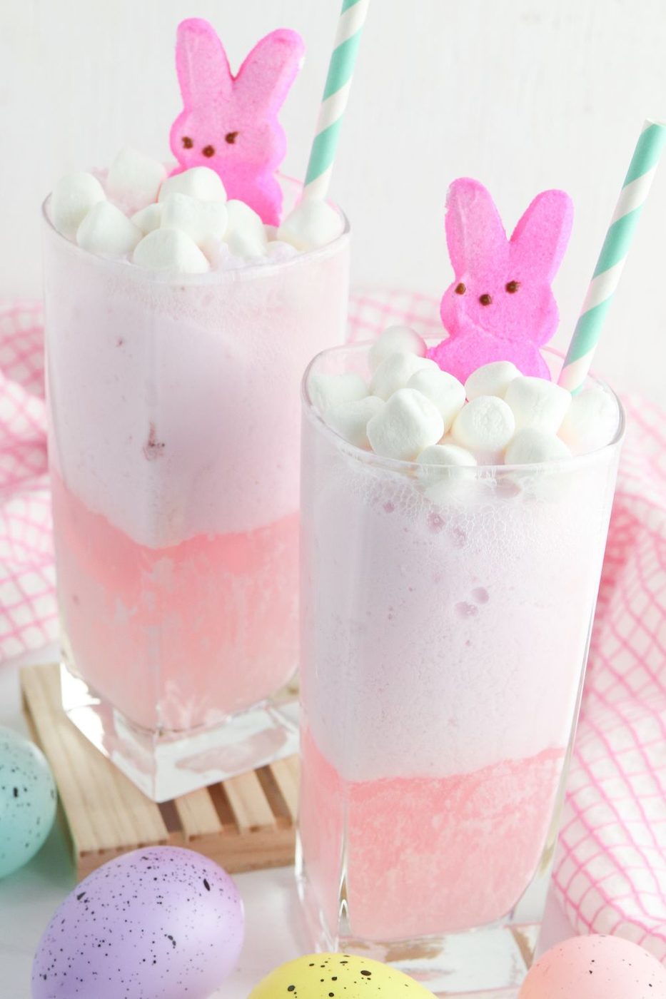 two glasses of strawberry punch on a table with Easter decorations around it 