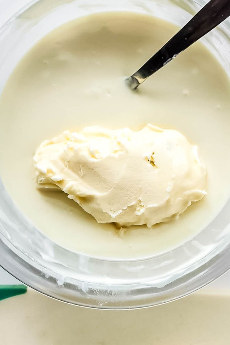 frozen ice cream in a bowl of melted white chocolate 