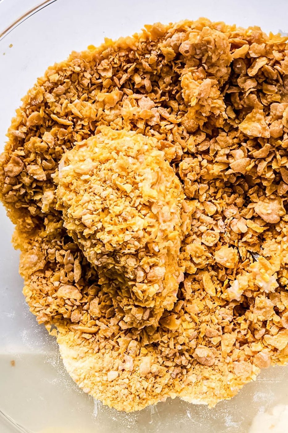 ice cream rolled in a bowl of crushed corn flakes that makes it look like a chicken leg