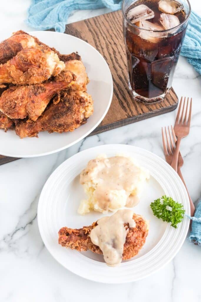 Fried Chicken Legs on plate with a plate in front with one leg and mashed potatoes
