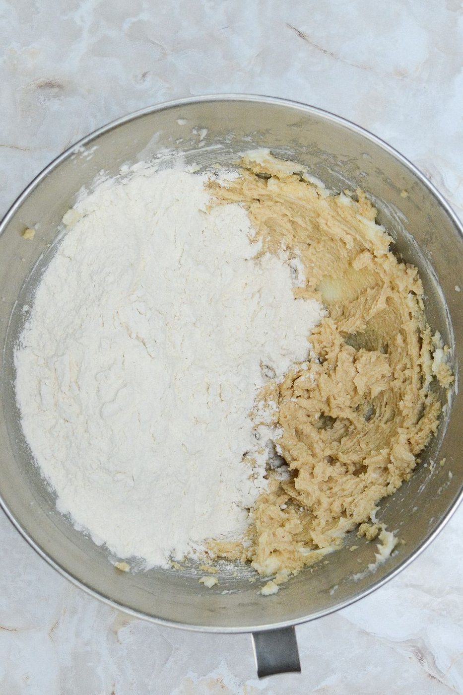 dry and wet ingredients of cookie dough in a metal bowl