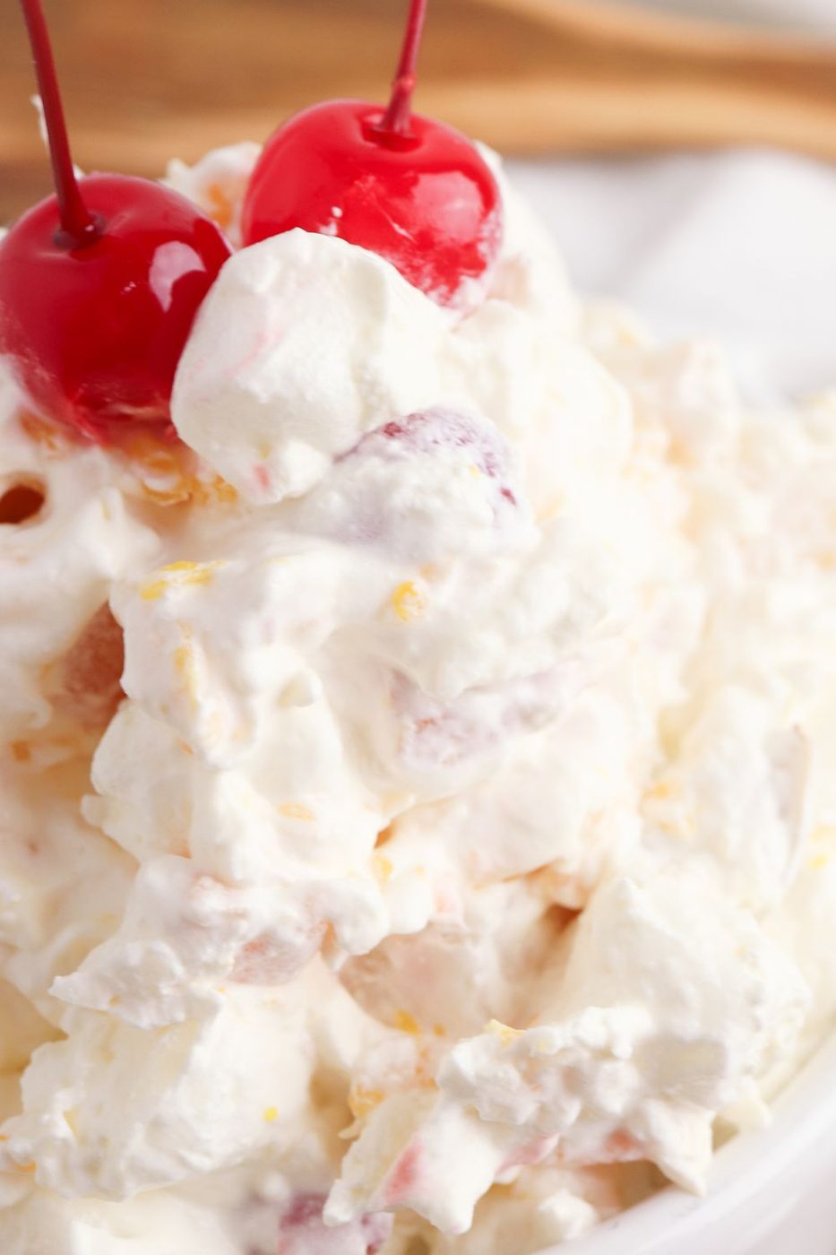 fruit salad in a bowl close up with cherries on top