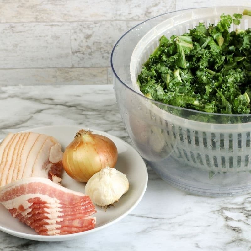 bacon onions, garlic and kale on counter