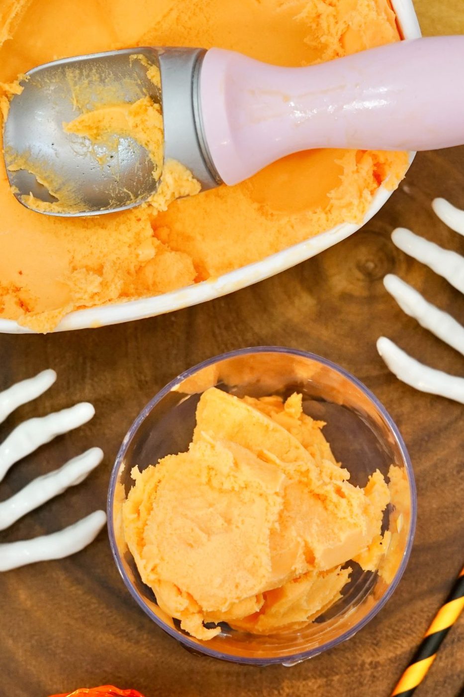 sherbet scooped into a glass with sherbet in a container on table