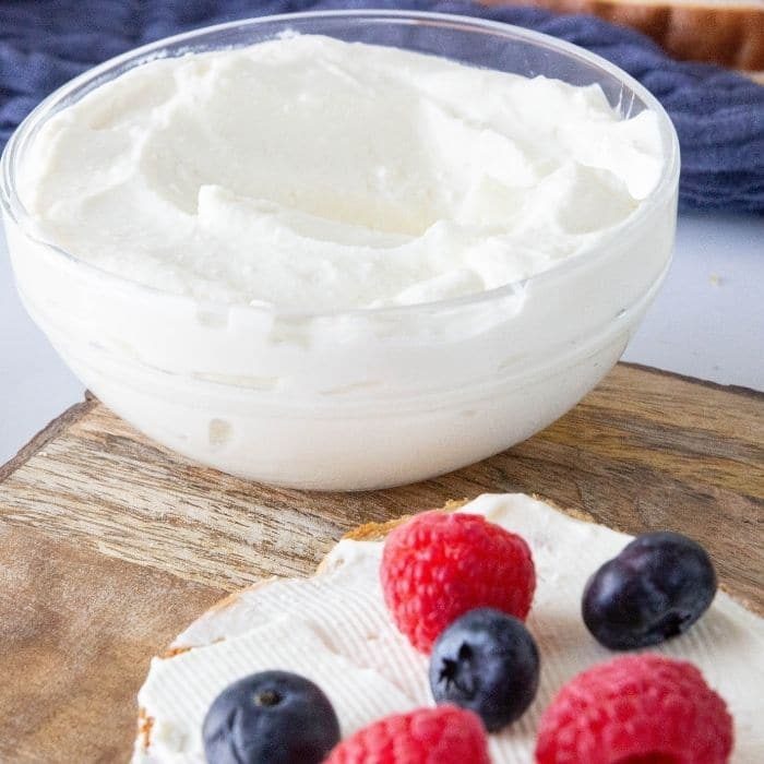 cream cheese spread on bread with fresh berries.