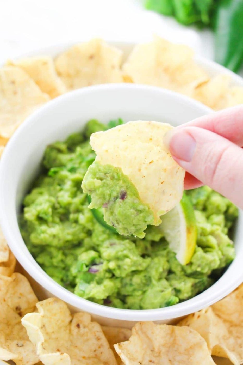dipping a chip in guac dip