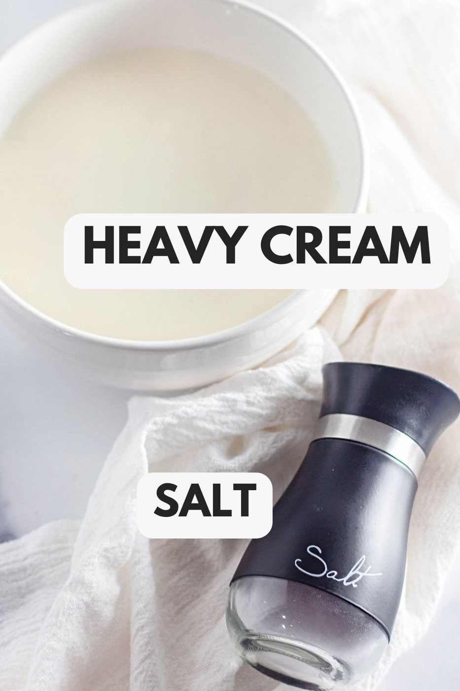 heavy cream in a white bowl and salt on table 