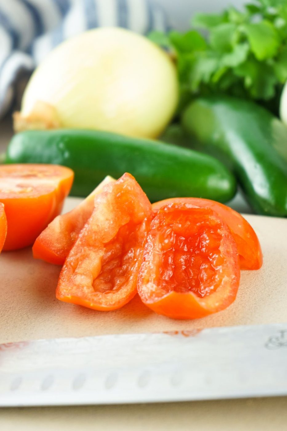 tomatoes on a cutting board with the seeds cut out of them so it is skin and flesh only 