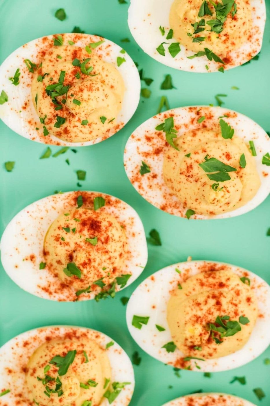 hummus filled eggs on a green platter on table 
