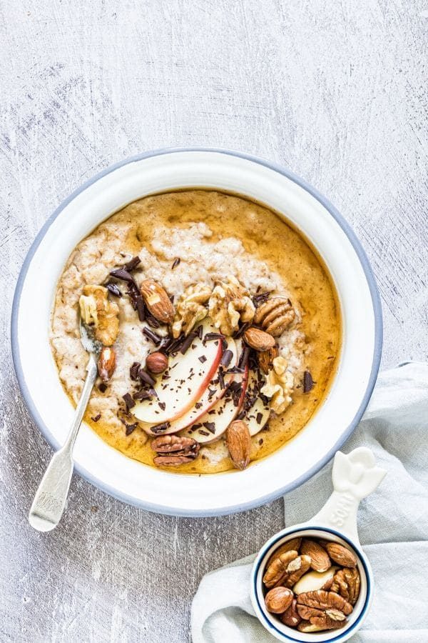 bowl of oatmeal with bowl of nuts by it