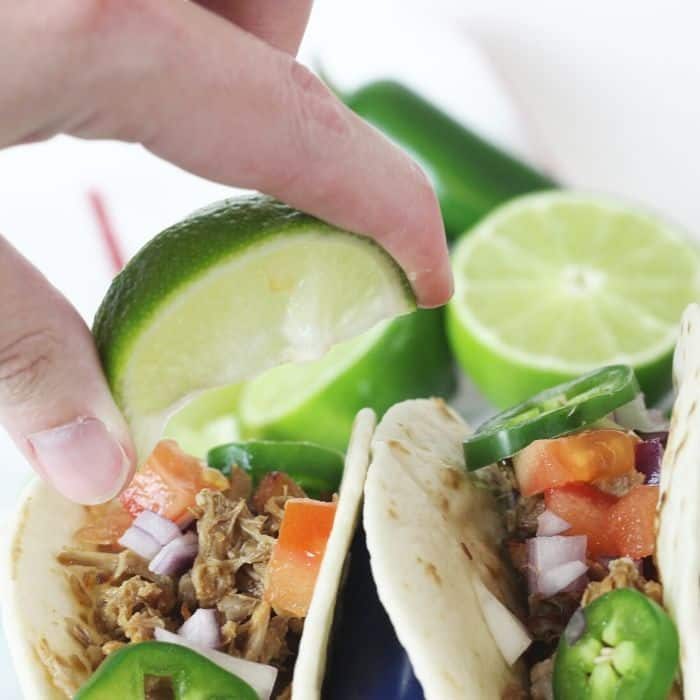 squeezing lime over a pork carnita