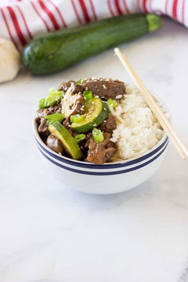 hibachi steak in a bowl with zucchini behind it