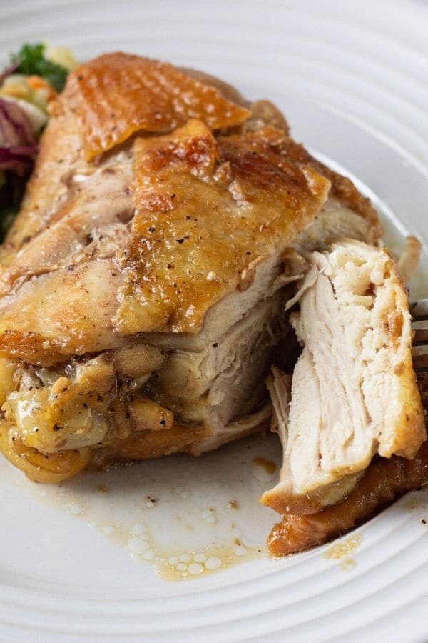 instant pot chicken thighs on a plate cut off a piece