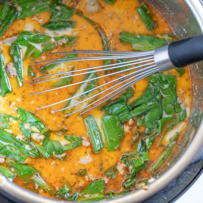 soup with wild ramps and a whisk in Instant Pot 