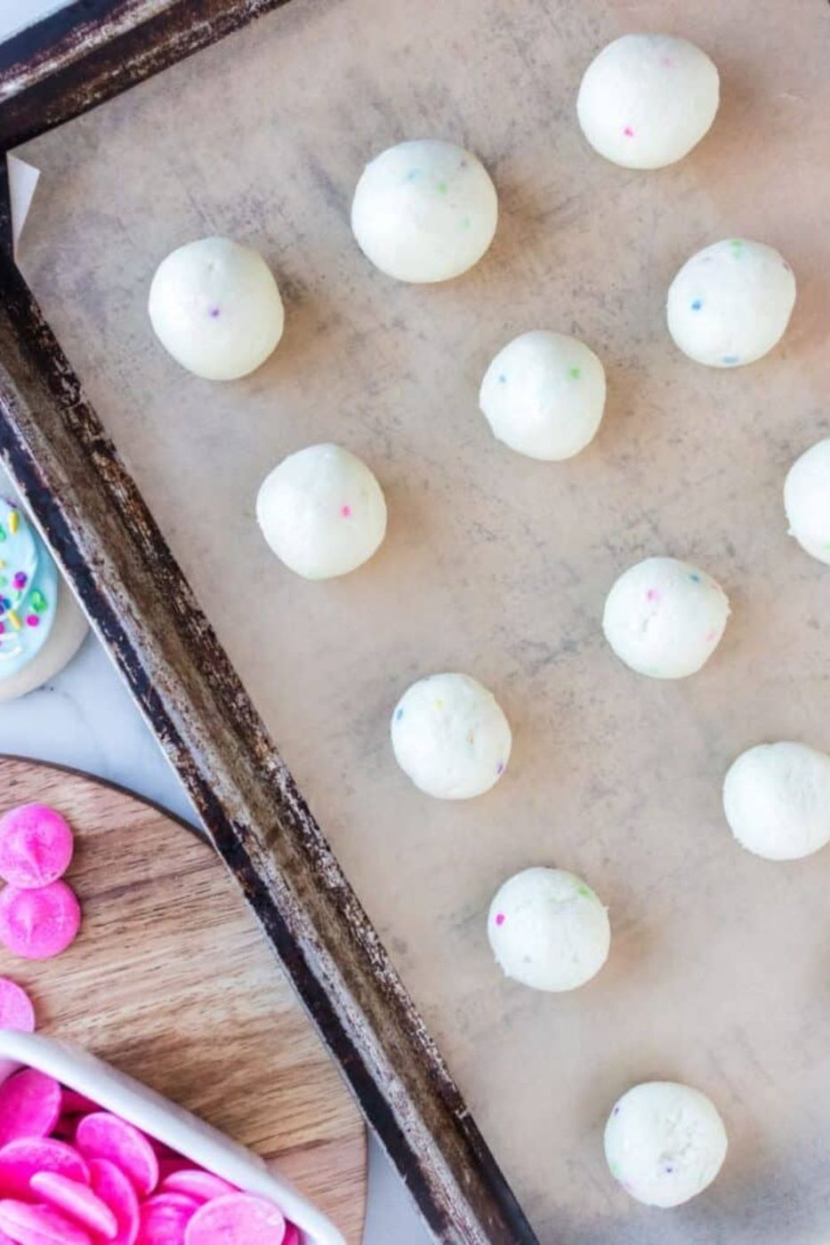 sugar cookie cake pops rolled in balls sitting on a cookie sheet 