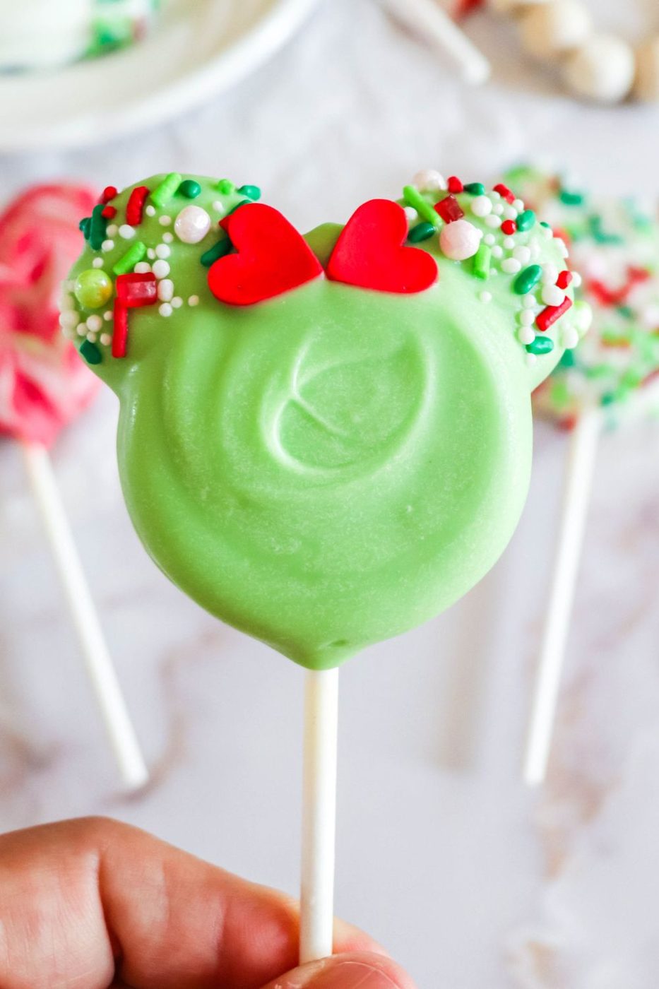 Minnie Mouse Chocolate Dipped Oreo pop in hand 