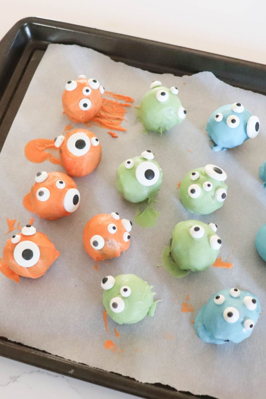 Halloween truffles on baking tray with wax paper under it
