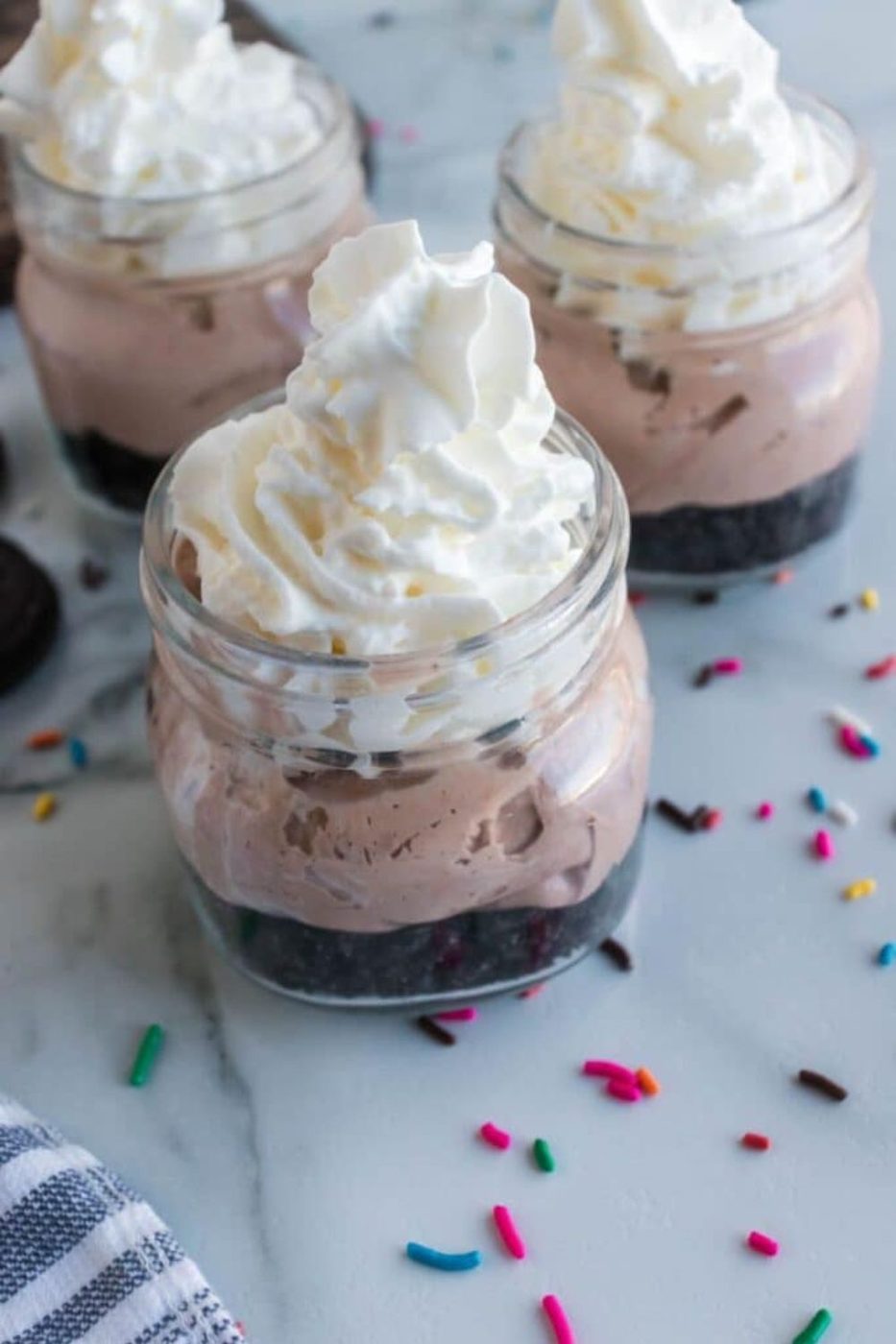 mason jars with oreo cookie crust and a chocolate cheesecake filling 