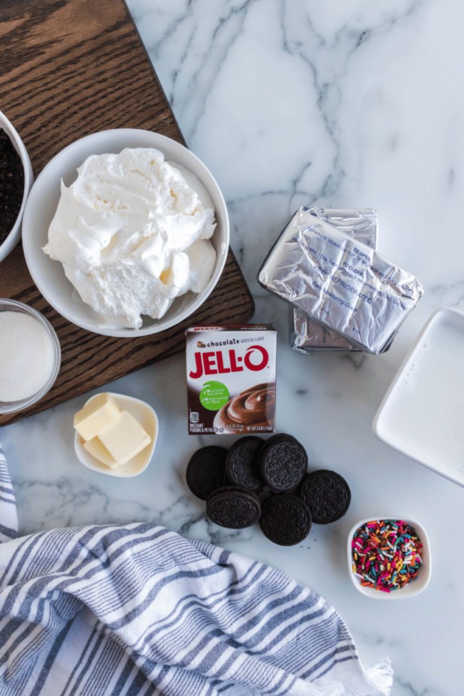 ingredients for no bake oreo cheesecakes in single serve containers on table 