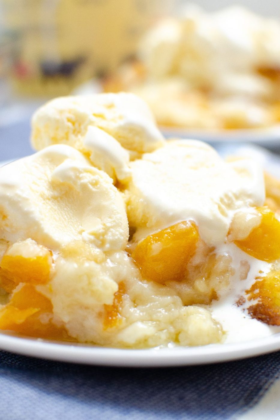 peach cobbler on a plate with ice cream on top slowly melting 