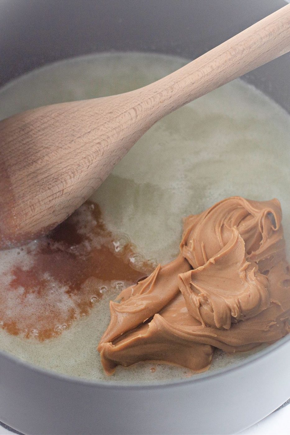 mixing peanut butter and vanilla in a sugar and butter boiling mixture