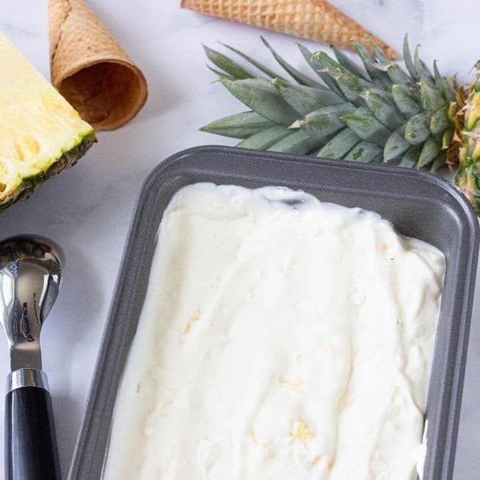 pineapple ice cream with pineapple and ice cream cones by it 