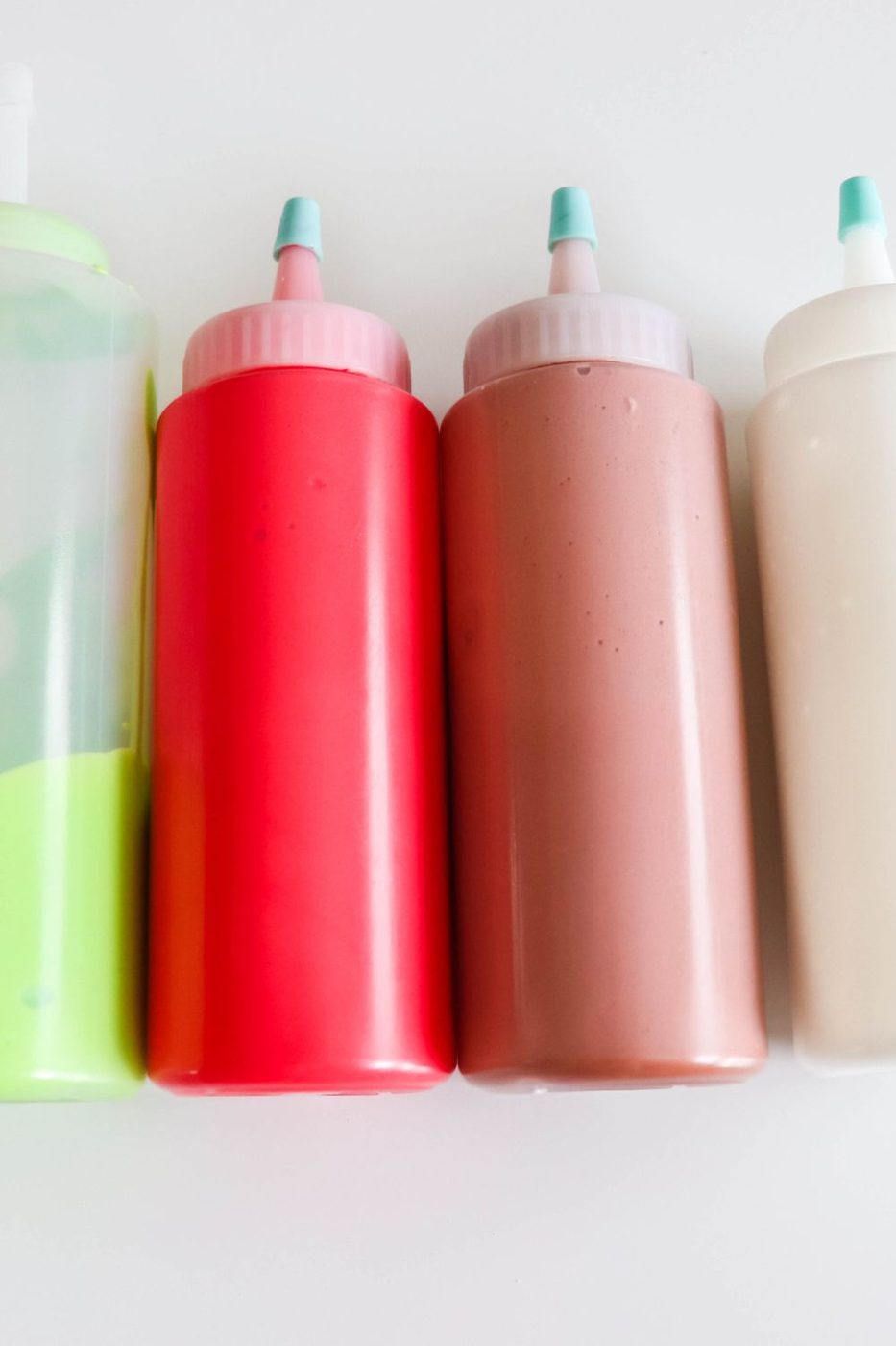 royal icing in plastic squirt bottles on table 